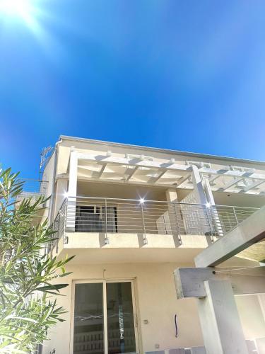 a white house with a balcony on it at Alloggio Ulivi in Isola Rossa