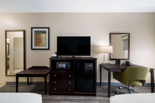 a hotel room with a television and a desk and chair at Hampton Inn Marshall in Marshall