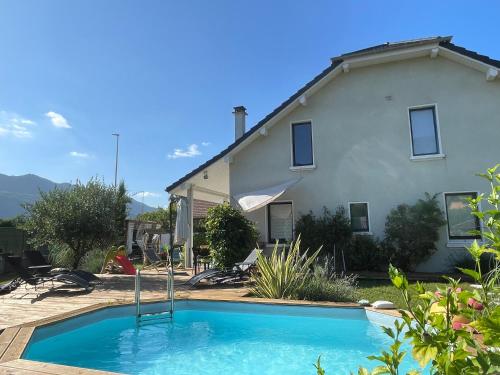 a swimming pool in front of a house at La cigale et la fourmi savoisienne - gîtes in Aix-les-Bains