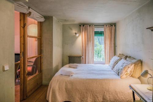 1 dormitorio con cama y ventana en Rectoría de Castellar, en La Vall de Bianya