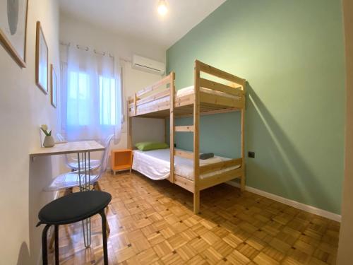 a room with two bunk beds and a table and stool at MediTerra Stay in the heart of Athens in Athens