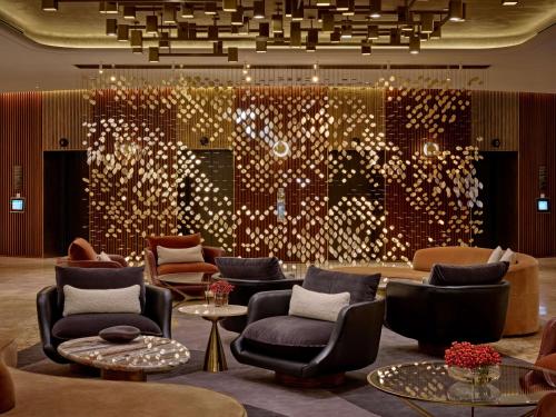 a lobby with chairs and a large wall with lights at London Hilton on Park Lane in London