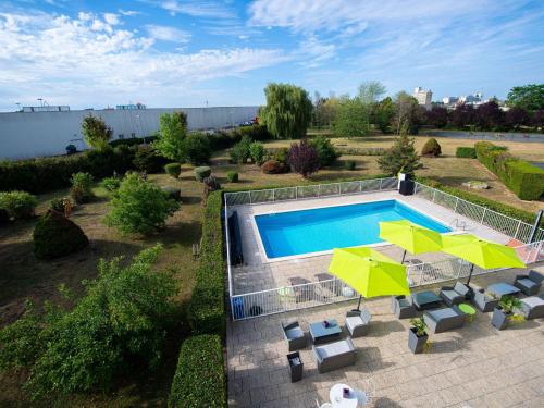 an overhead view of a swimming pool in a yard at ibis Styles Gien in Gien