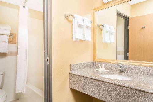 a bathroom with a sink and a mirror and a toilet at Baymont by Wyndham Kasson Rochester Area in Kasson
