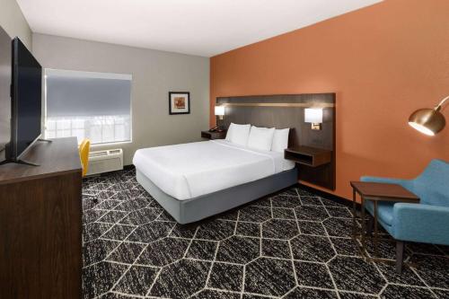 une chambre avec un lit, un bureau et une télévision dans l'établissement La Quinta by Wyndham Olathe, à Olathe
