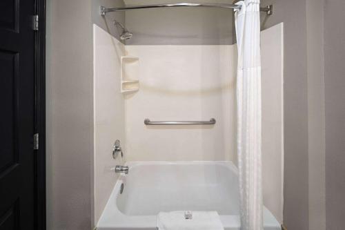 a white bathroom with a tub and a sink at La Quinta by Wyndham Olathe in Olathe