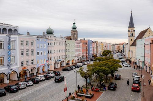 a city with cars parked on a street with buildings at Highlight am Stadtplatz Mühldorf - C4S COME4STAY - 2 Zimmer Wohnung I bis zu 5 Gäste in Mühldorf