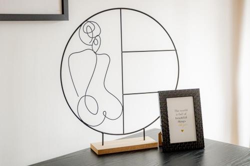 a mirror on a table next to a framed picture at Highlight am Stadtplatz Mühldorf - C4S COME4STAY - 2 Zimmer Wohnung I bis zu 5 Gäste in Mühldorf
