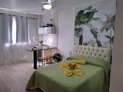 a bedroom with a green bed with a yellow towel on it at Apartamento CondominioEuropa centro de barra mansa in Barra Mansa