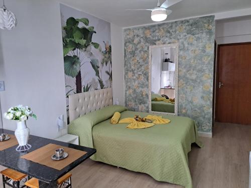 a bedroom with a green bed and a mirror at Apartamento CondominioEuropa centro de barra mansa in Barra Mansa