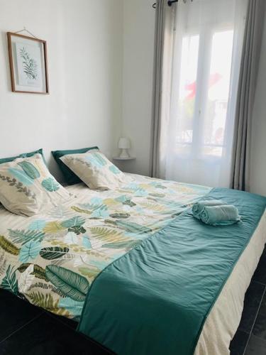 - un lit avec une couette bleue et une fenêtre dans l'établissement *Secret Sand* Cheerfull Town beach house villa, à La Baie-Orientale