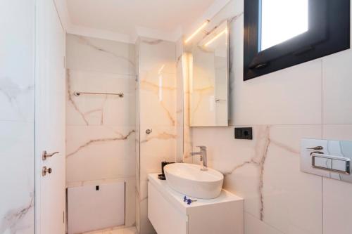 a white bathroom with a sink and a mirror at Villa Sherbella in Fethiye