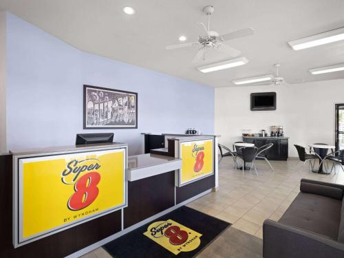 a waiting room with a super sign and chairs at Super 8 by Wyndham Dunnigan in Dunnigan
