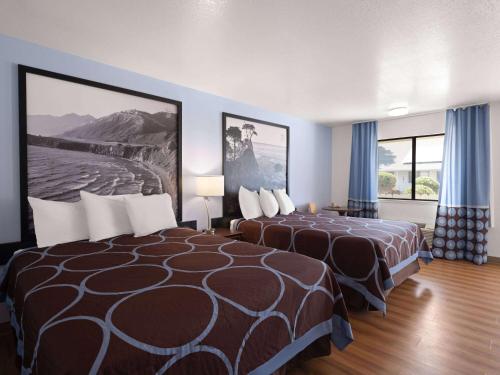 a hotel room with two beds and two windows at Super 8 by Wyndham Dunnigan in Dunnigan