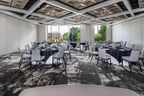 een conferentieruimte met tafels en stoelen en grote ramen bij Hyatt Centric Charlotte SouthPark in Charlotte