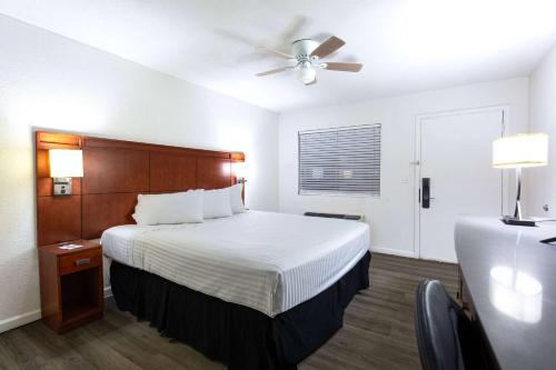 a hotel room with a bed and a ceiling fan at Travelodge by Wyndham Parker in Parker