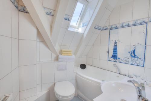 a white bathroom with a toilet and a sink at Abaluga 4A in Wenningstedt