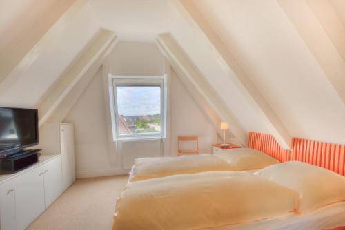 two beds in a room with a window at Abaluga 4A in Wenningstedt