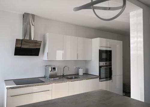 a kitchen with white cabinets and a sink at Lorenc street apartment in Zlín