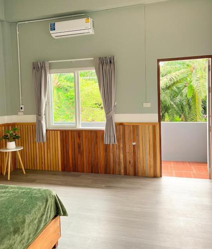 a bedroom with a bed and a window at private room with share bathroom at Little wild house Khaosok in Khao Sok