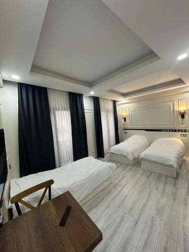 a hotel room with two beds and a table at Mitra otel in Diyarbakır