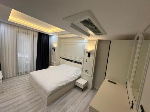 a small bedroom with a white bed and a window at Mitra otel in Diyarbakır