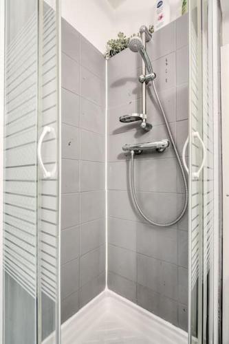 une douche avec une porte vitrée dans une salle de bain dans l'établissement Studio Cosy proche de Tête d'Or, à Villeurbanne