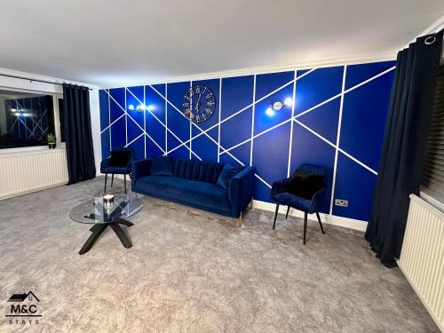 凱特林的住宿－Kettering/Stylish/ Perfect for Contractors，客厅设有蓝色的墙壁,上面有时钟