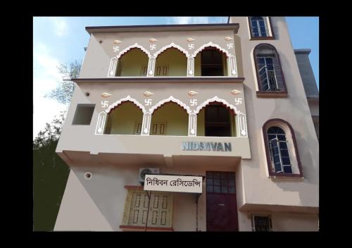 Nidhivan Residency في Navadwīp: مبنى أبيض طويل عليه علامة