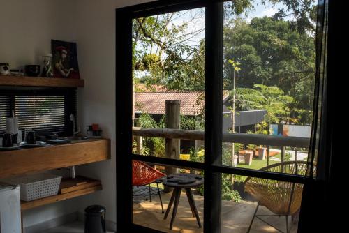 a door to a balcony with a view of a yard at Pousada Vila do Mel in Pontal do Paraná
