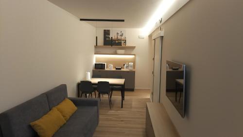 ein Wohnzimmer mit einem Sofa und einem Tisch mit Stühlen in der Unterkunft fragilerooms in Dolo