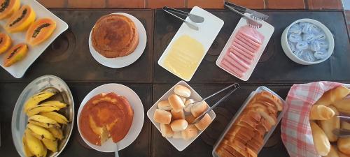 una mesa cubierta con diferentes tipos de alimentos diferentes en Pousada Pau Brasil, en Guapimirim