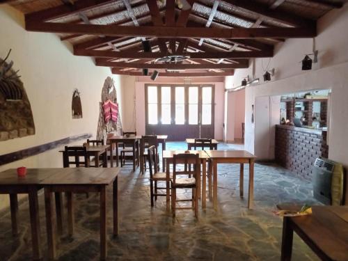 a restaurant with wooden tables and chairs in a room at Hotel Cactus Plaza in Purmamarca
