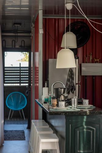 a kitchen with a green counter and a blue chair at Pousada Vila do Mel in Pontal do Paraná