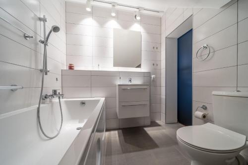 a white bathroom with a shower and a toilet at Trevilles Apartamenty Mountain View in Szklarska Poręba