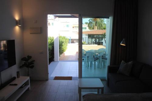 a living room with a door open to a patio at Pachi Beach Alisios Playa Corralejo in Corralejo