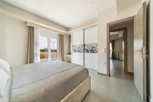 a bedroom with a large bed and a large window at Villa Rudi in Atsoupádhes