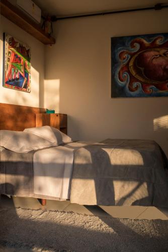 a bedroom with a bed and a painting on the wall at Pousada Vila do Mel in Pontal do Paraná