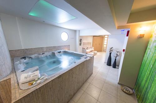 un gran cuarto de baño con jacuzzi en Vournelis Beach Hotel and Spa, en Nea Iraklitsa