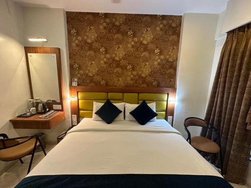 1 dormitorio con 1 cama grande con espejo y escritorio en SriKrishna Paradise Hotel Thane Navi Mumbai, en Thane