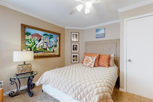 a bedroom with a bed and a painting on the wall at Seascape Gem in Galveston