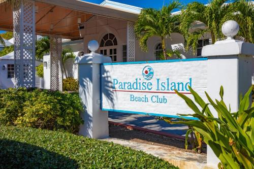 a sign for paradise island beach club in front of a house at Paradise Island Beach Club Ocean View Villas in Creek Village