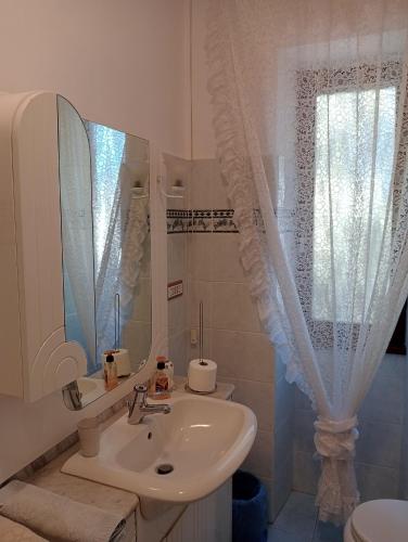 a white bathroom with a sink and a mirror at Aeroporto Ciampino a soli 600 Mt Bici Grill Decimo Miglio in Ciampino