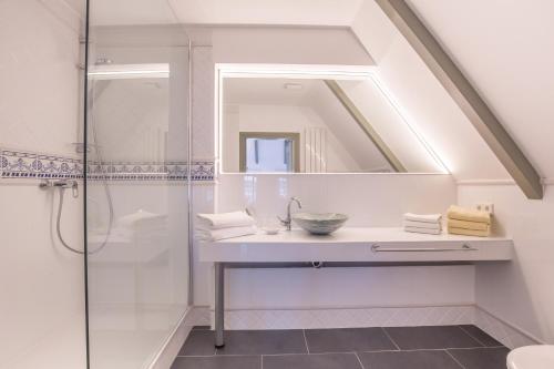 a bathroom with a sink and a shower at Friesenhaus Sara S2 in Wenningstedt