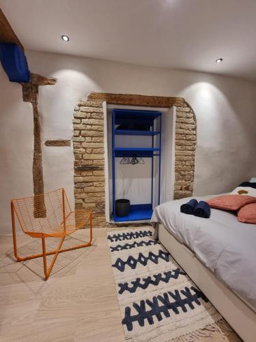 a bedroom with a bed and a chair and a window at Les appartements Hyper centre in Strasbourg