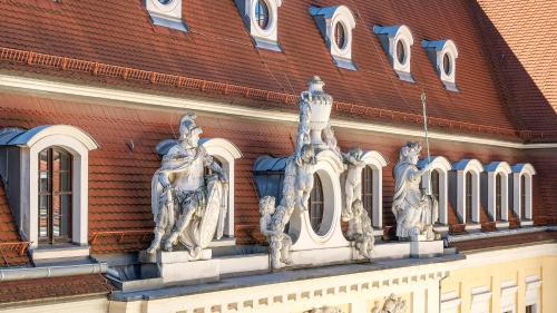 a building with a statue on the side of it at Hotel Taschenbergpalais Kempinski in Dresden