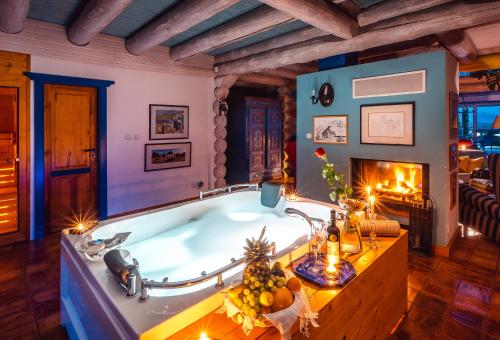 a bath tub in a room with a fireplace at Luxusní srub u Rájeckých Teplic in Stránske