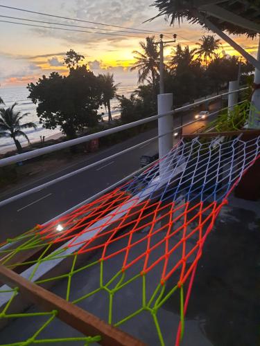 a net on the side of a road with a sunset at White Surfing Beach Resort in Unawatuna
