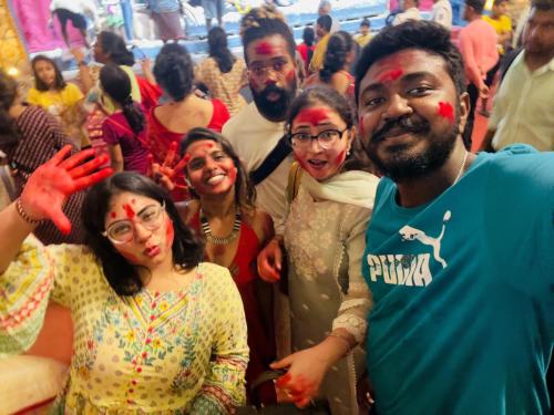 grupa ludzi stojących w tłumie z farbą na sobie w obiekcie Guten Tag Kolkata w mieście Kolkata