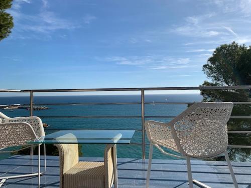 una mesa y sillas en un balcón con vistas al océano en Paraíso Costa Dorada, en Tarragona